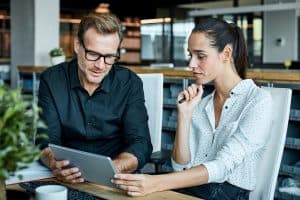 Man and woman looking at tablet.