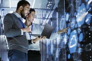 Man and woman looking at computer servers.